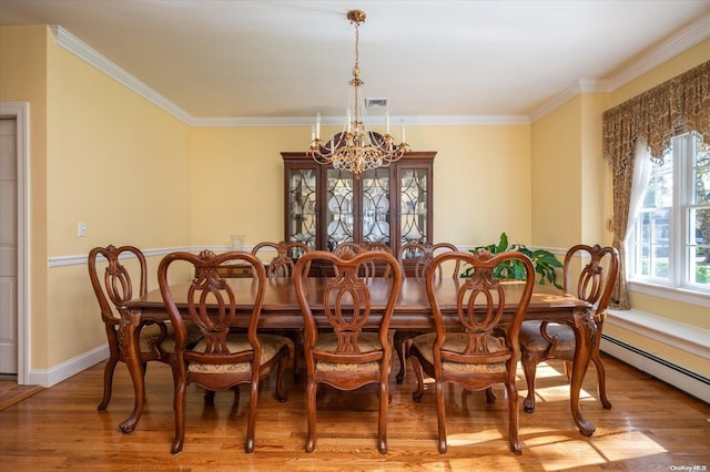 dining space with ornamental molding, a notable chandelier, and hardwood / wood-style flooring