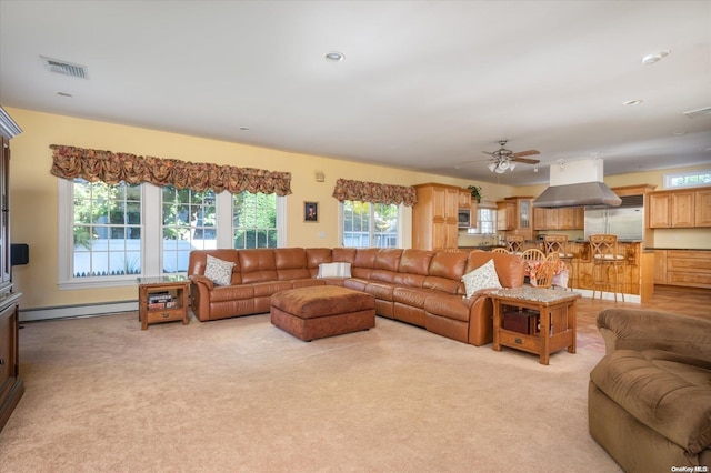 carpeted living room featuring baseboard heating and ceiling fan