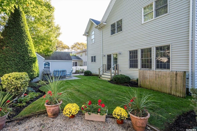 back of property featuring a yard and an outdoor structure