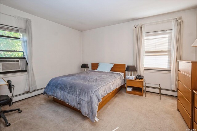 bedroom featuring light carpet, baseboard heating, and cooling unit