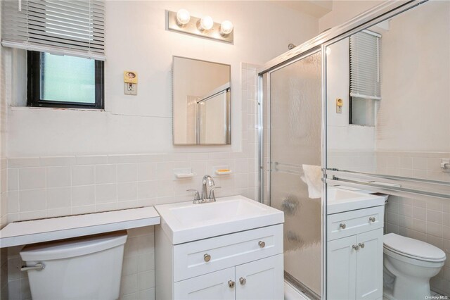 bathroom with vanity, tile walls, and toilet