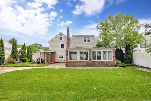 back of property featuring a lawn and a patio area