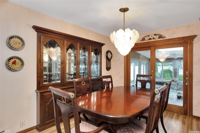 dining space featuring light hardwood / wood-style flooring and a notable chandelier