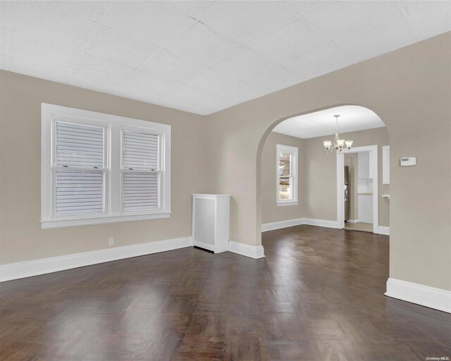 94-51 226th St, Floral Park, NY 11001 - empty room featuring arched walkways, a chandelier, and baseboards