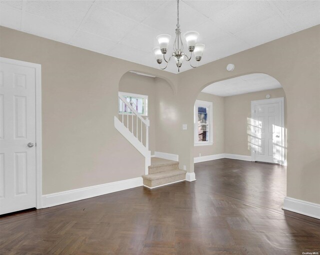94-51 226th St, Floral Park, NY 11001 - unfurnished living room with arched walkways, a chandelier, stairs, and baseboards