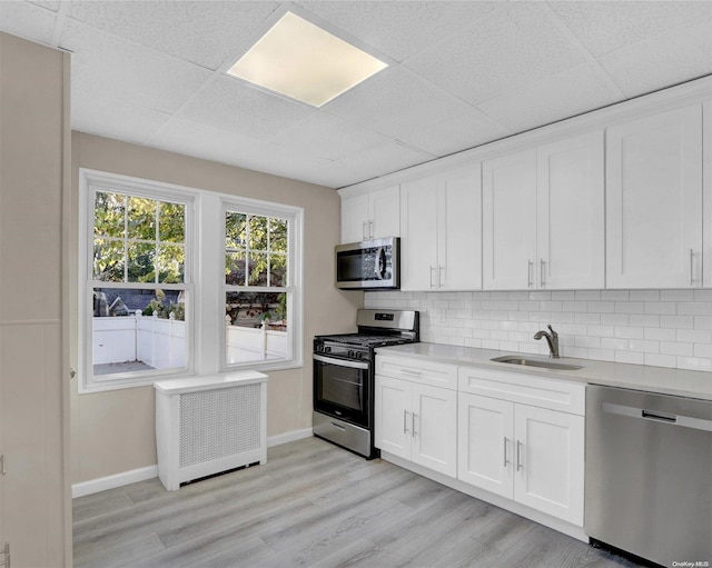 94-51 226th St, Floral Park, NY 11001 - kitchen with appliances with stainless steel finishes, a sink, light countertops, baseboards, and a drop ceiling