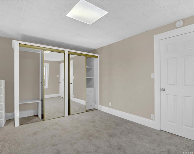 unfurnished bedroom with light colored carpet and multiple closets