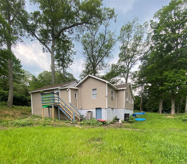 back of house with a wooden deck and a lawn