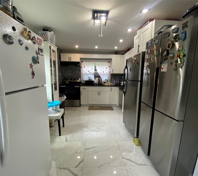 kitchen with decorative backsplash, appliances with stainless steel finishes, and white cabinetry