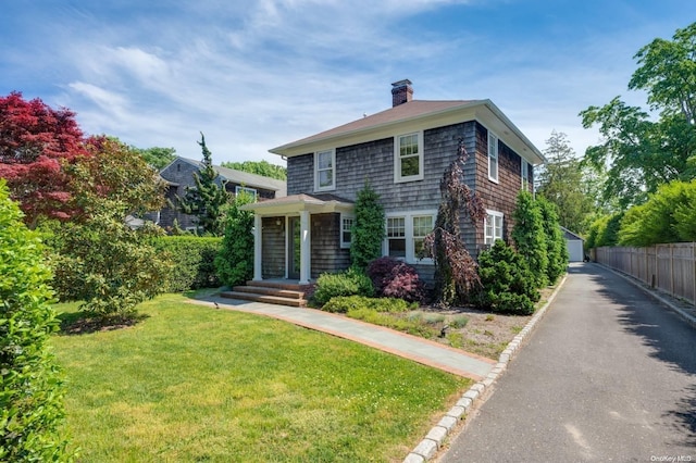 view of front of property featuring a front lawn, an outdoor structure, and a garage