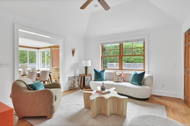 living room featuring plenty of natural light, light hardwood / wood-style floors, ceiling fan, and vaulted ceiling