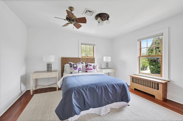 bedroom with radiator, ceiling fan, and dark wood-type flooring