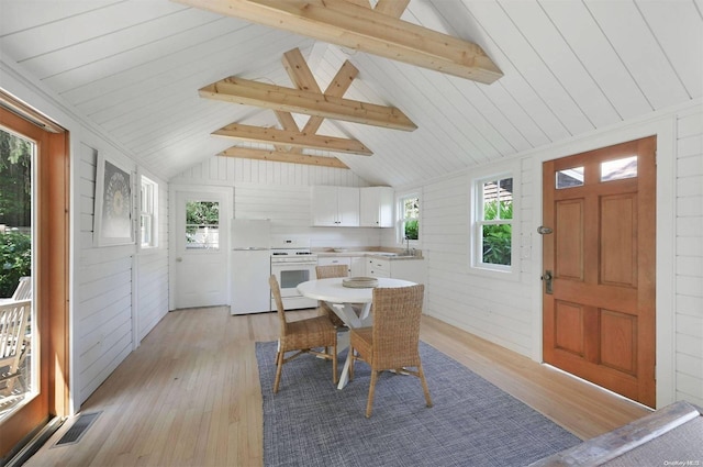 dining room featuring vaulted ceiling with beams and plenty of natural light