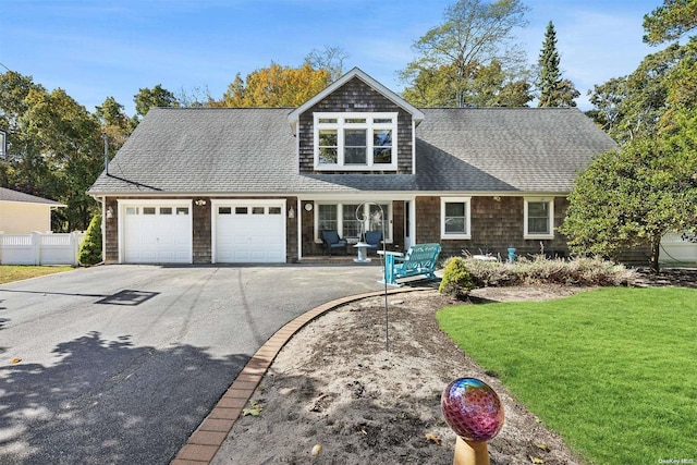 cape cod house featuring a garage and a front yard