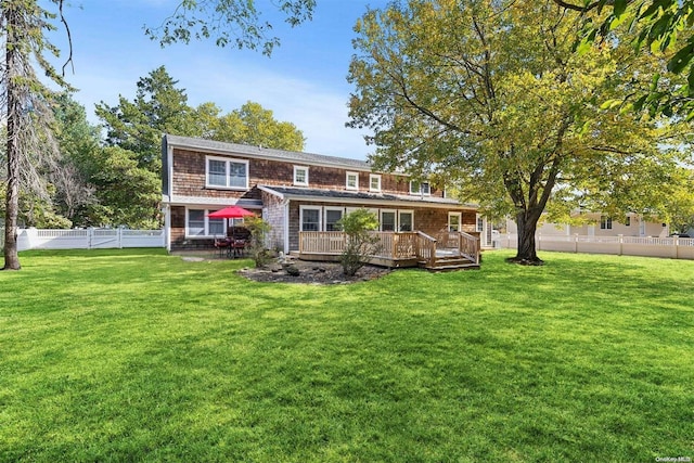 back of property featuring a yard and a deck