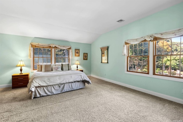 carpeted bedroom featuring lofted ceiling and multiple windows