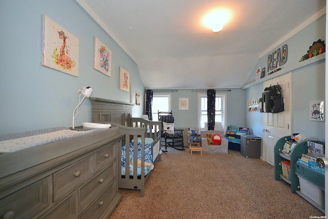 carpeted bedroom with a crib and vaulted ceiling