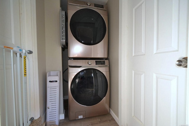 laundry area with light wood-type flooring and stacked washer and dryer