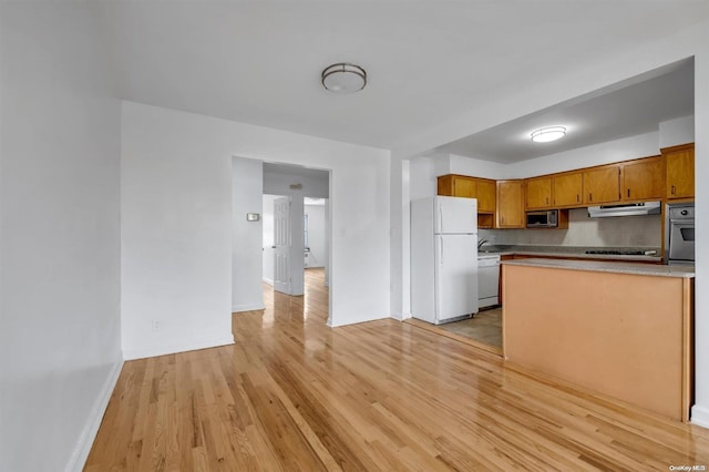 kitchen with backsplash, light wood-type flooring, sink, and appliances with stainless steel finishes