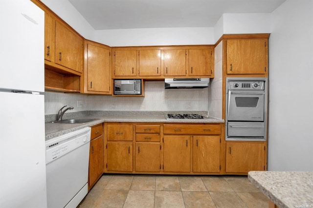 kitchen with tasteful backsplash, sink, light tile patterned floors, and appliances with stainless steel finishes