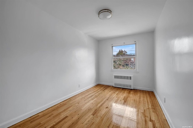 unfurnished room with light wood-type flooring and radiator