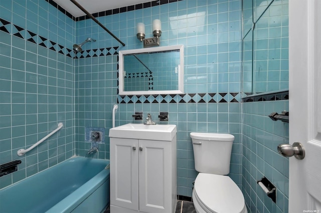 full bathroom featuring toilet, vanity, tile walls, and tiled shower / bath