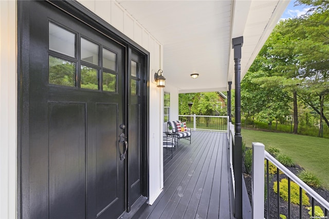 deck featuring covered porch and a lawn