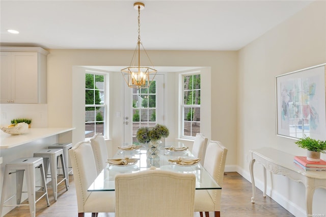 dining area with a chandelier, a healthy amount of sunlight, and light wood-type flooring