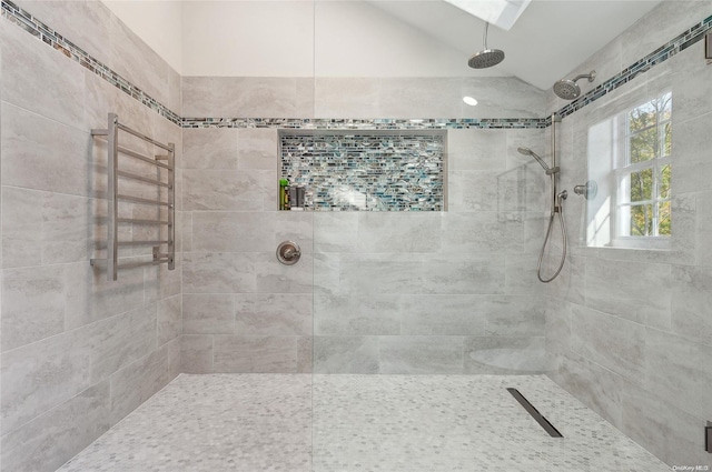 bathroom featuring lofted ceiling and tiled shower