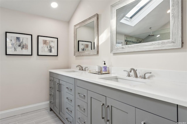 bathroom featuring hardwood / wood-style flooring, vanity, and lofted ceiling with skylight