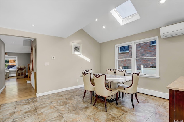 tiled dining area with a wall mounted air conditioner, lofted ceiling with skylight, and plenty of natural light