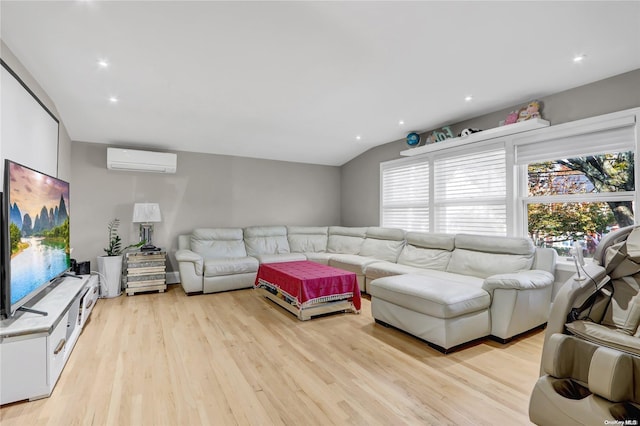 living room featuring a wall unit AC, lofted ceiling, and light wood-type flooring