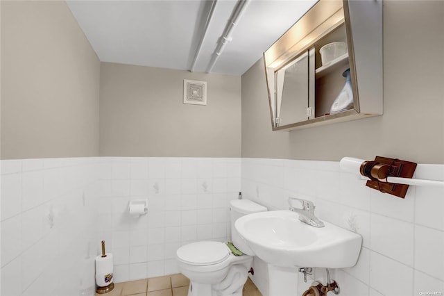 bathroom featuring tile patterned flooring, sink, toilet, and tile walls