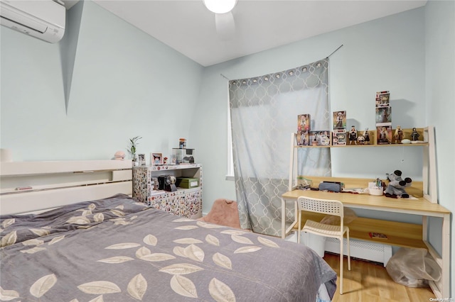 bedroom featuring hardwood / wood-style floors, ceiling fan, an AC wall unit, and baseboard heating