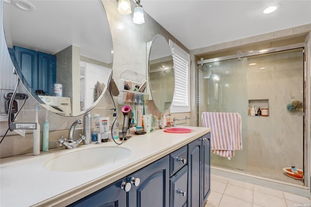 bathroom with tile patterned flooring, vanity, and a shower with door