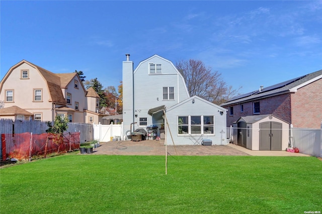 back of property featuring a yard, a shed, and a patio area