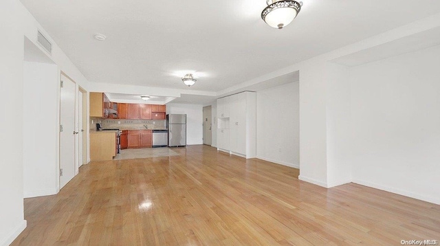 unfurnished living room with light hardwood / wood-style floors and sink