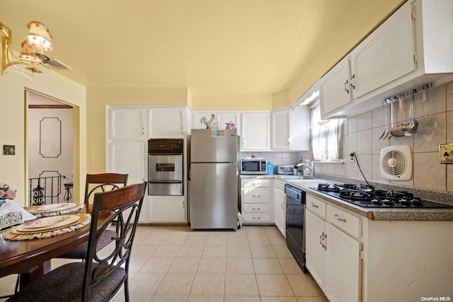 kitchen with tasteful backsplash, white cabinets, and stainless steel appliances