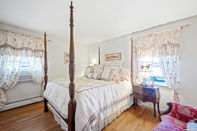 bedroom featuring wood-type flooring, cooling unit, and a baseboard heating unit