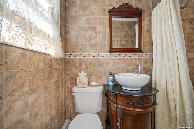 bathroom with vanity, toilet, and tile walls