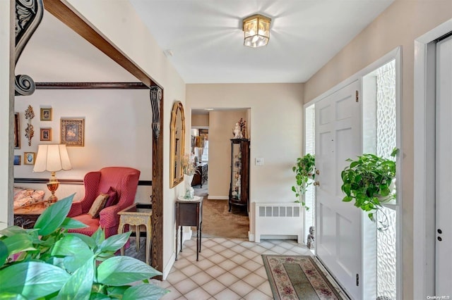 tiled foyer featuring radiator heating unit