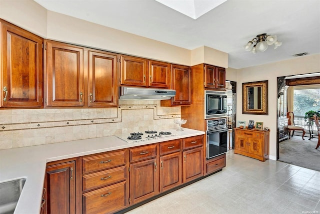 kitchen featuring backsplash, a skylight, and black appliances