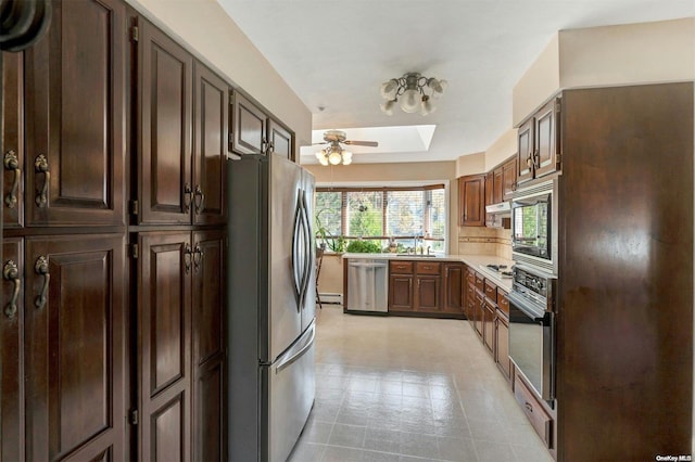 kitchen featuring dark brown cabinetry, stainless steel appliances, and a skylight