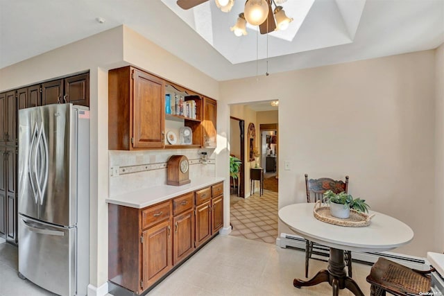 kitchen featuring backsplash, stainless steel fridge, ceiling fan, and baseboard heating