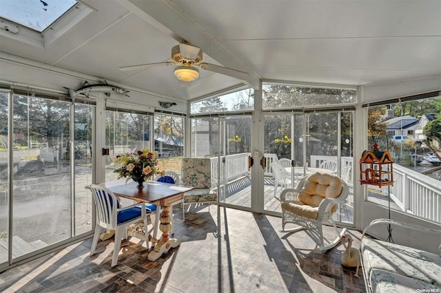 sunroom featuring vaulted ceiling with skylight and ceiling fan