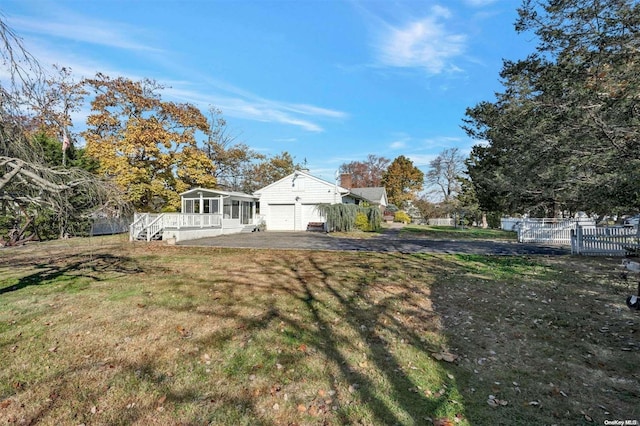 view of yard with a garage and a sunroom