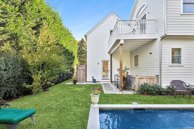 back of house featuring a yard and a balcony