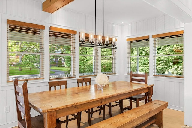 dining space featuring wood walls and light wood-type flooring