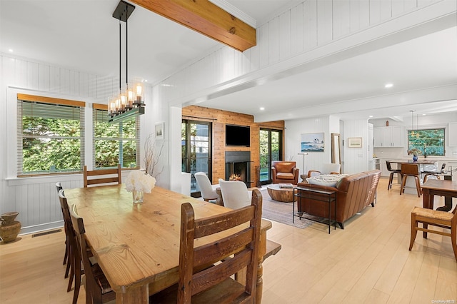 dining area featuring light hardwood / wood-style flooring, a wealth of natural light, and an inviting chandelier