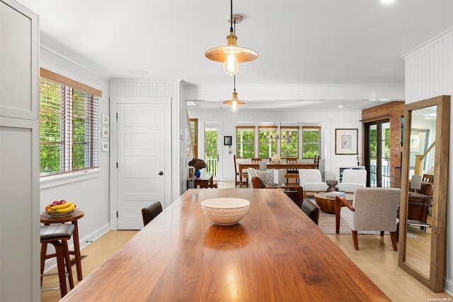 dining space with light hardwood / wood-style floors, plenty of natural light, and crown molding